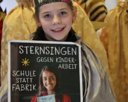 Judith präsentiert das Plakat der Sternsingeraktion 2026. (Foto: Jens Völker)